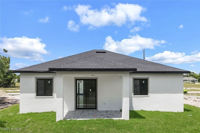 rear view of property with a lawn and a patio