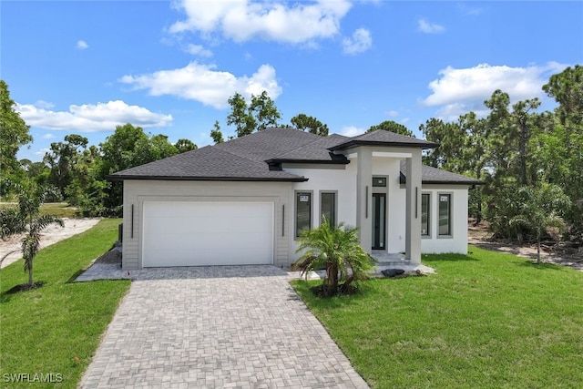 prairie-style home with a garage, roof with shingles, decorative driveway, stucco siding, and a front lawn