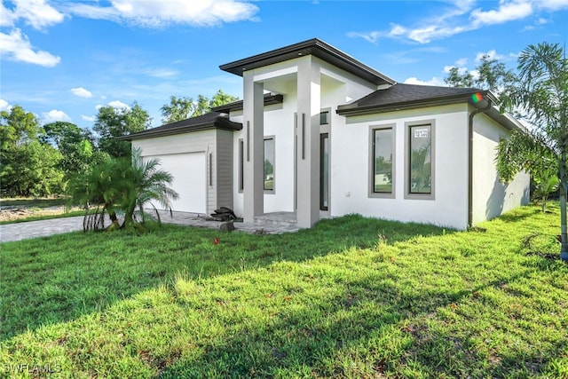 back of property with a garage and a yard