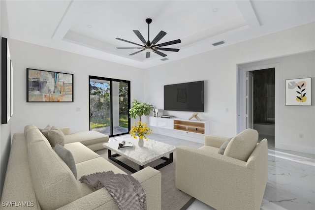 living room featuring a raised ceiling and ceiling fan