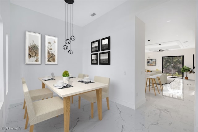 dining space with a ceiling fan, marble finish floor, visible vents, and baseboards