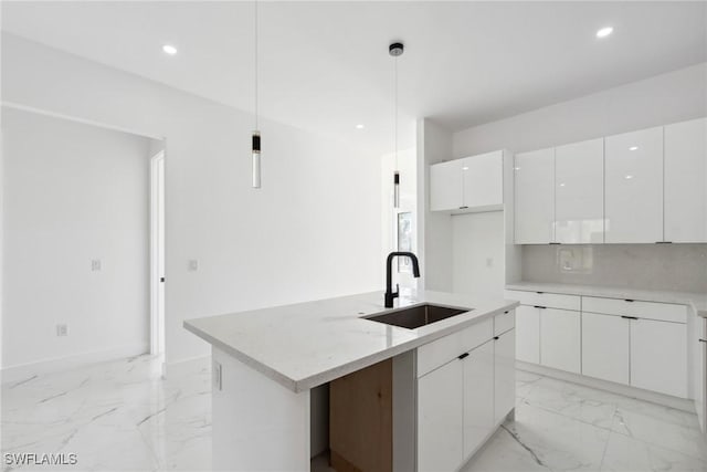 kitchen featuring marble finish floor, decorative backsplash, white cabinets, a sink, and modern cabinets