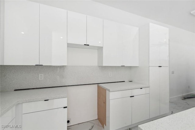 kitchen with marble finish floor, light countertops, decorative backsplash, white cabinetry, and modern cabinets