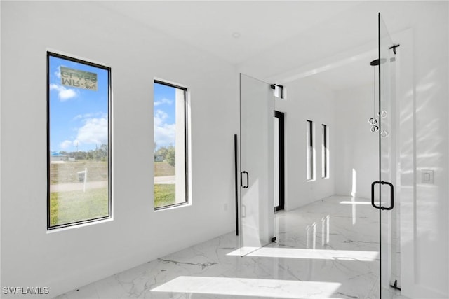 bathroom with marble finish floor, a shower stall, visible vents, and baseboards