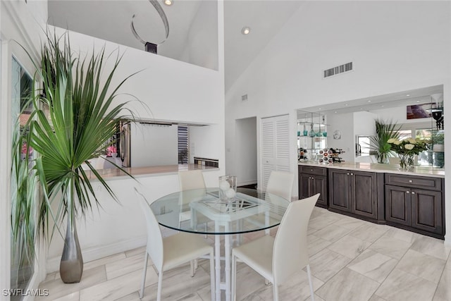 dining space featuring high vaulted ceiling