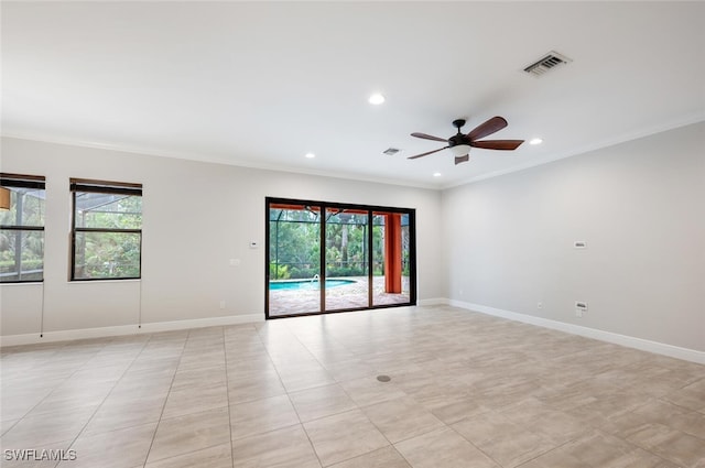 tiled spare room featuring ceiling fan, crown molding, and plenty of natural light