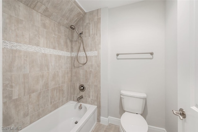 bathroom featuring tiled shower / bath combo, hardwood / wood-style flooring, and toilet