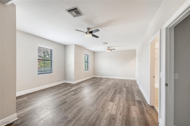 empty room with a wealth of natural light, ceiling fan, and wood-type flooring