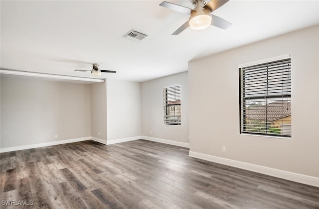 spare room featuring ceiling fan, hardwood / wood-style flooring, and a healthy amount of sunlight