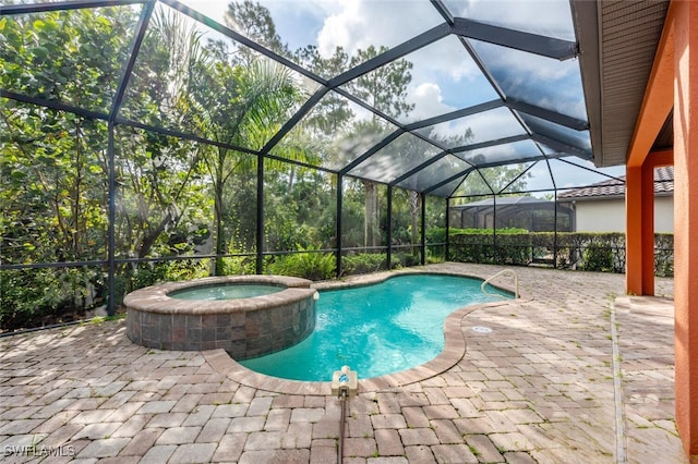 view of pool with glass enclosure, an in ground hot tub, and a patio