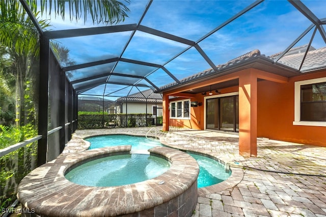 view of swimming pool featuring an in ground hot tub, glass enclosure, ceiling fan, and a patio