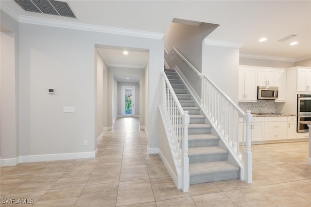 staircase with tile patterned flooring and crown molding