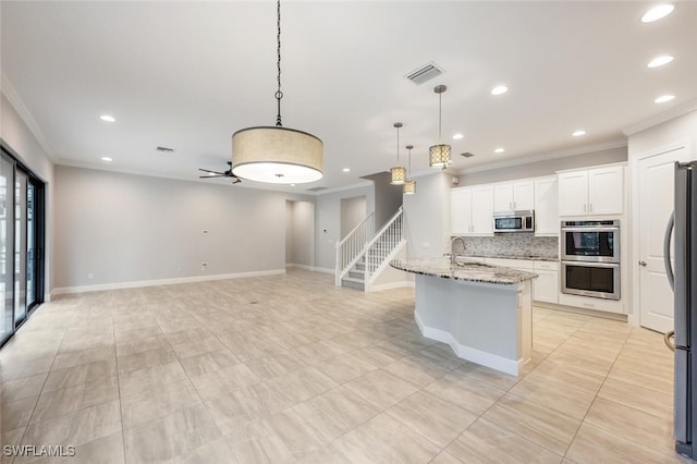 kitchen with tasteful backsplash, white cabinetry, appliances with stainless steel finishes, light stone countertops, and sink