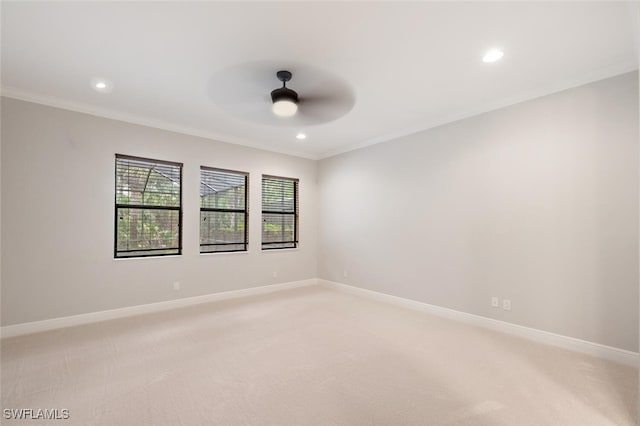 carpeted spare room with ceiling fan and crown molding