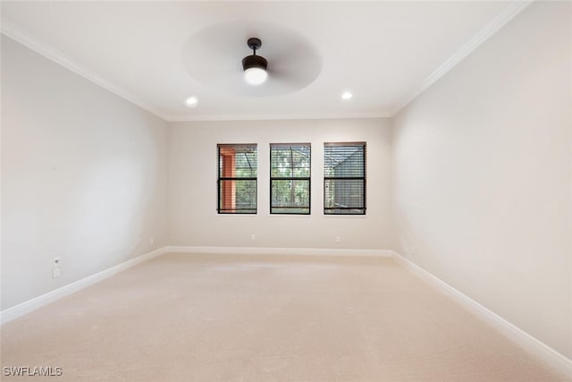 carpeted empty room featuring ceiling fan and crown molding