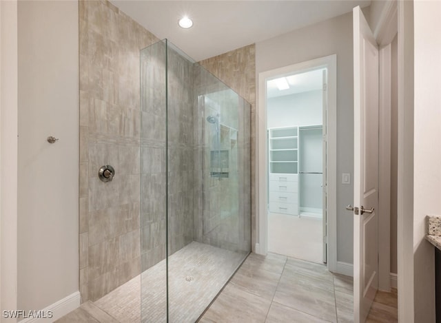 bathroom with tiled shower, vanity, and tile patterned floors