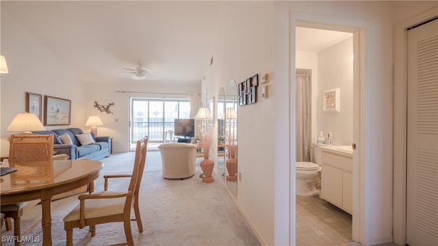 dining room with ceiling fan and light carpet