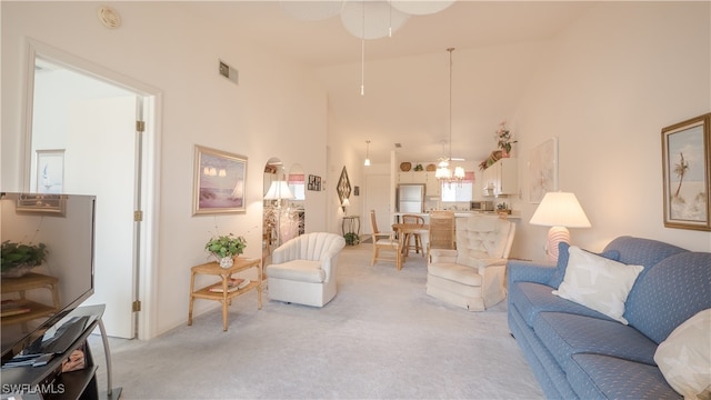 living room with light colored carpet, a high ceiling, and ceiling fan