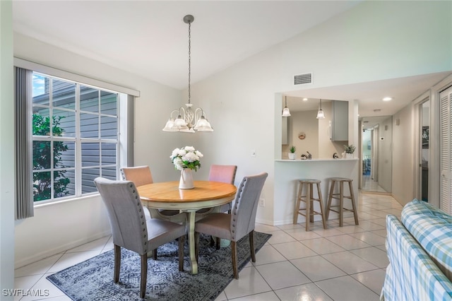 tiled dining area featuring lofted ceiling and a notable chandelier