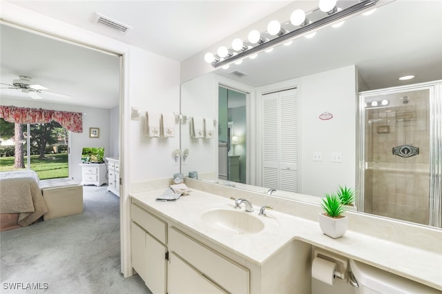 bathroom with vanity, ceiling fan, and a shower with shower door