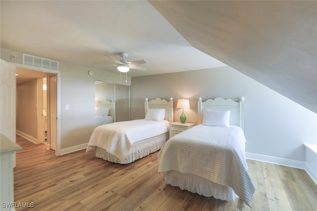 bedroom featuring a closet, ceiling fan, vaulted ceiling, and light wood-type flooring