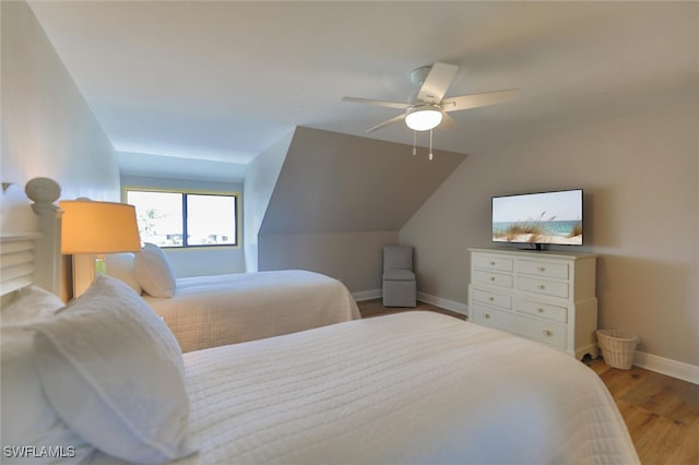 bedroom with ceiling fan, light hardwood / wood-style flooring, and lofted ceiling