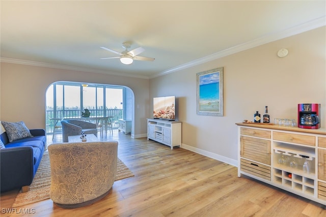 living room featuring ceiling fan, crown molding, and light hardwood / wood-style flooring