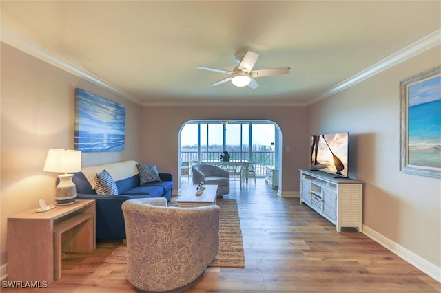 living room with ceiling fan, light wood-type flooring, and ornamental molding