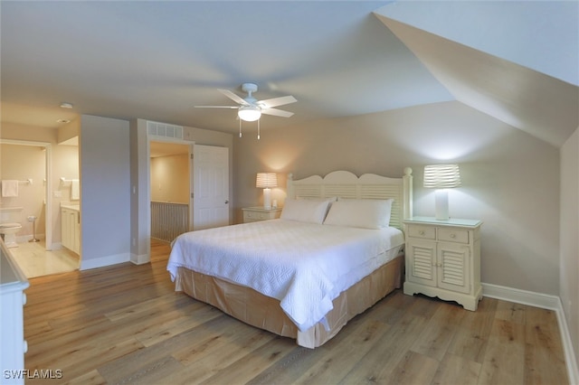 bedroom with ceiling fan, ensuite bath, light hardwood / wood-style floors, and lofted ceiling