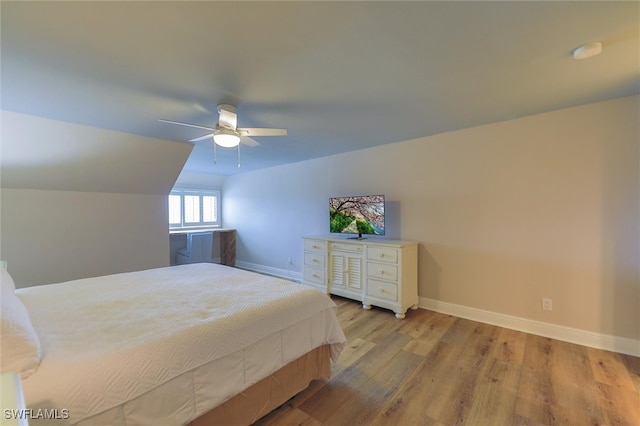 bedroom featuring ceiling fan, light hardwood / wood-style flooring, and lofted ceiling