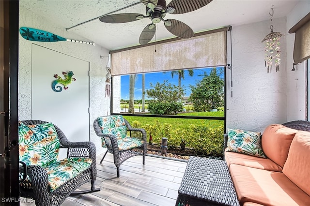 sunroom / solarium featuring a ceiling fan