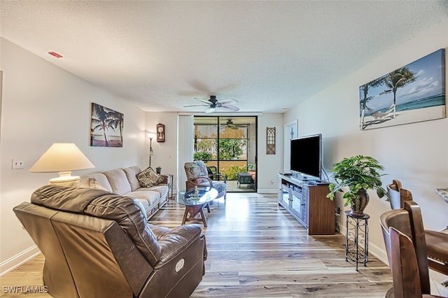 living room featuring a textured ceiling, ceiling fan, and wood-type flooring