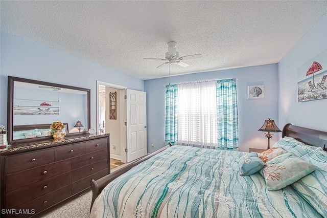 bedroom featuring a textured ceiling, ceiling fan, and light colored carpet