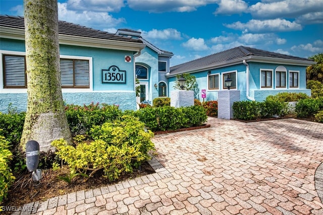 view of front of home featuring a tile roof and stucco siding