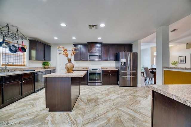 kitchen with a center island, appliances with stainless steel finishes, sink, and dark brown cabinetry