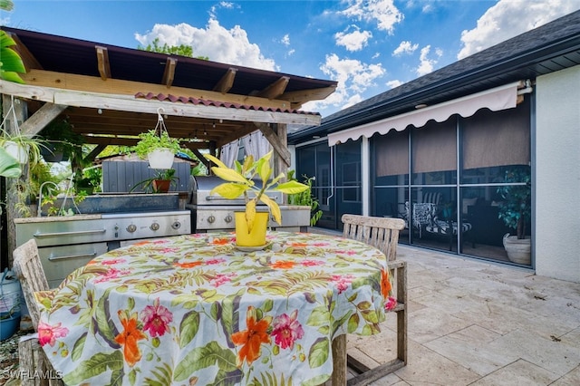 view of patio with a grill and a sunroom