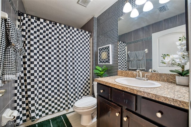 bathroom with vanity, toilet, and a textured ceiling