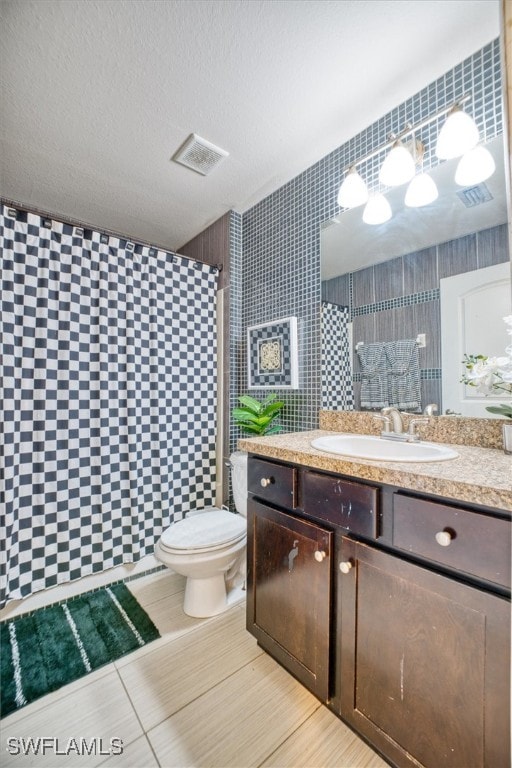 bathroom featuring vanity, a textured ceiling, and toilet