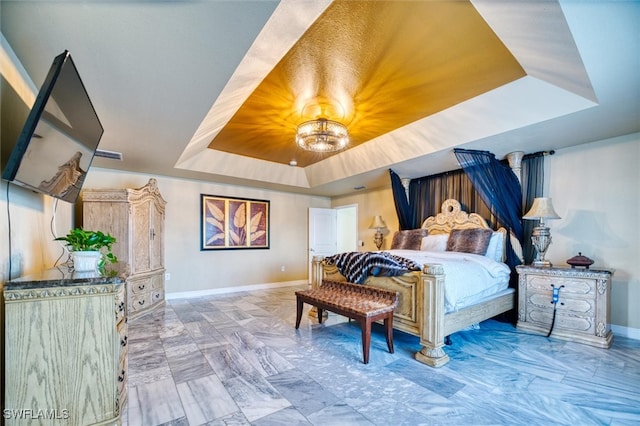 bedroom featuring a raised ceiling and an inviting chandelier