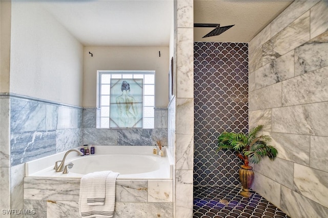 bathroom with independent shower and bath and a textured ceiling