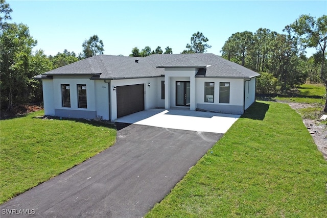 view of front of property with a front lawn and a garage