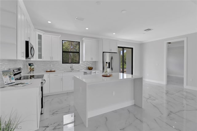 kitchen featuring light tile patterned flooring, a wealth of natural light, a center island, and stainless steel appliances