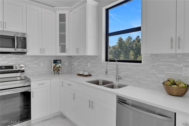 kitchen featuring sink, stainless steel appliances, decorative backsplash, and white cabinets