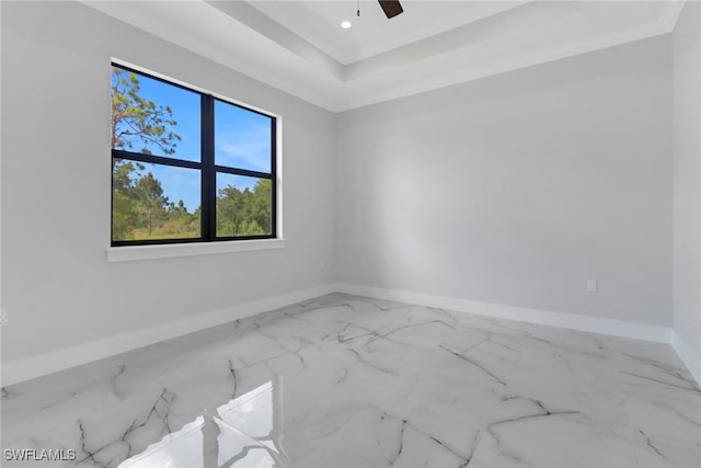 empty room featuring ceiling fan and a tray ceiling