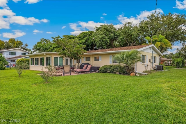 rear view of property with central air condition unit, a patio area, stucco siding, and a yard