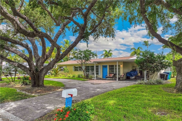 ranch-style home featuring a front yard and a carport