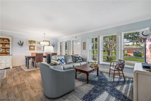 living room with ornamental molding, wood finished floors, and baseboards