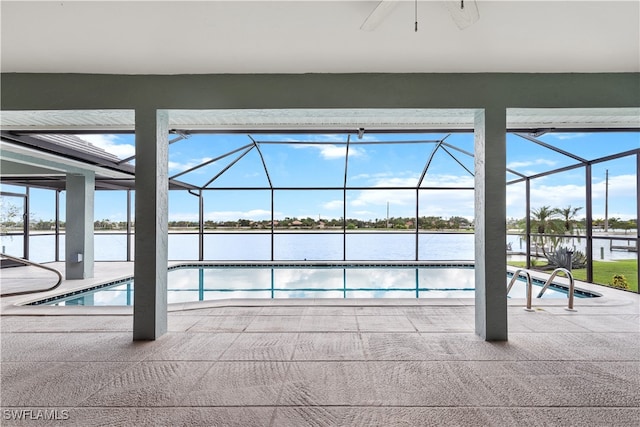 view of pool with a lanai, ceiling fan, a patio area, and a water view