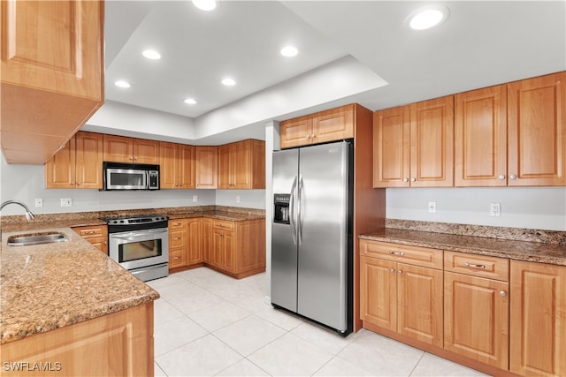 kitchen with light tile patterned floors, light stone counters, stainless steel appliances, and sink