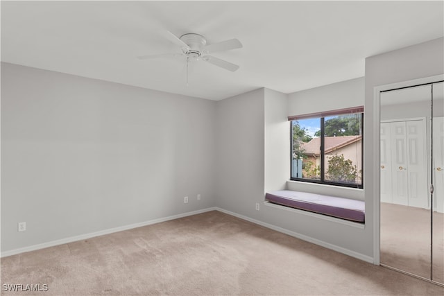 unfurnished room featuring ceiling fan and light carpet